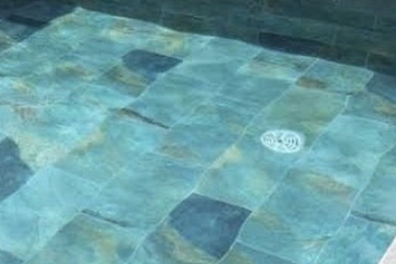 Piedra natural en tonos verde azulado, el revestimiento que llevará la piscina
